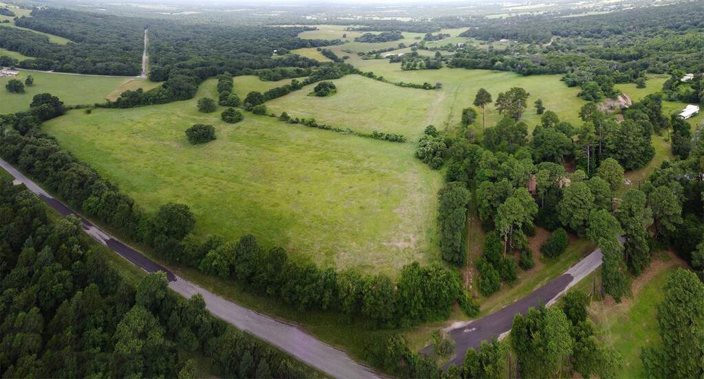 Aerial view of property's location featuring a heavily wooded area and rural landscape