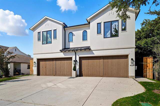 View of front facade featuring a standing seam roof, concrete driveway, a metal roof, a garage, and stucco siding