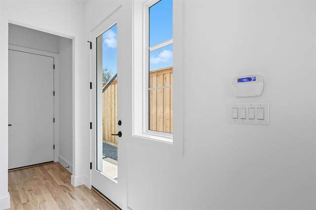 Doorway to outside featuring wood finished floors and baseboards