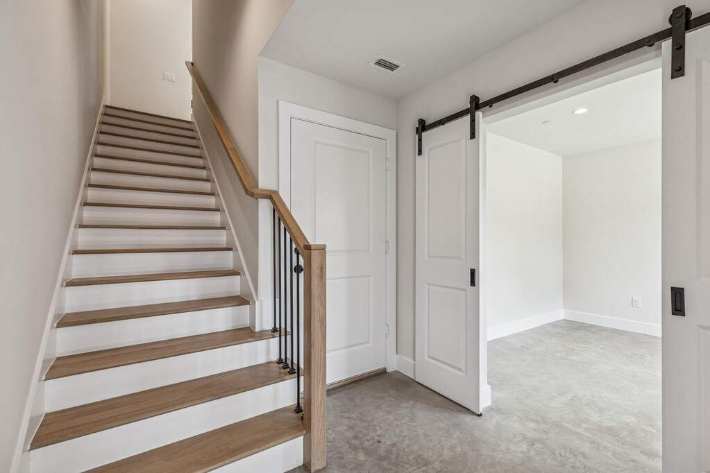 Study on 1st floor with a barn door, concrete floors, and recessed lighting