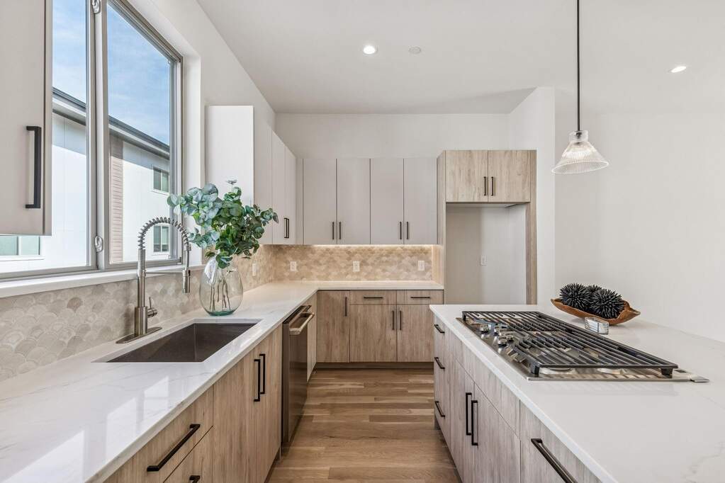 Kitchen featuring Quartz countertops, GE cafe series appliances, Visual Comfort light fixtures and real solid 3/4" real hardwood floors
