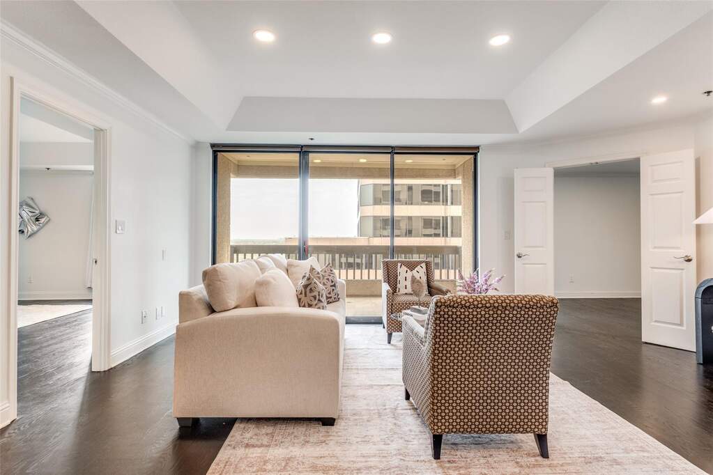 This view highlights the thoughtful layout of the home, showcasing the split-bedroom floor plan. The dark floors contrast beautifully with the crisp white walls for a modern gallery feel.