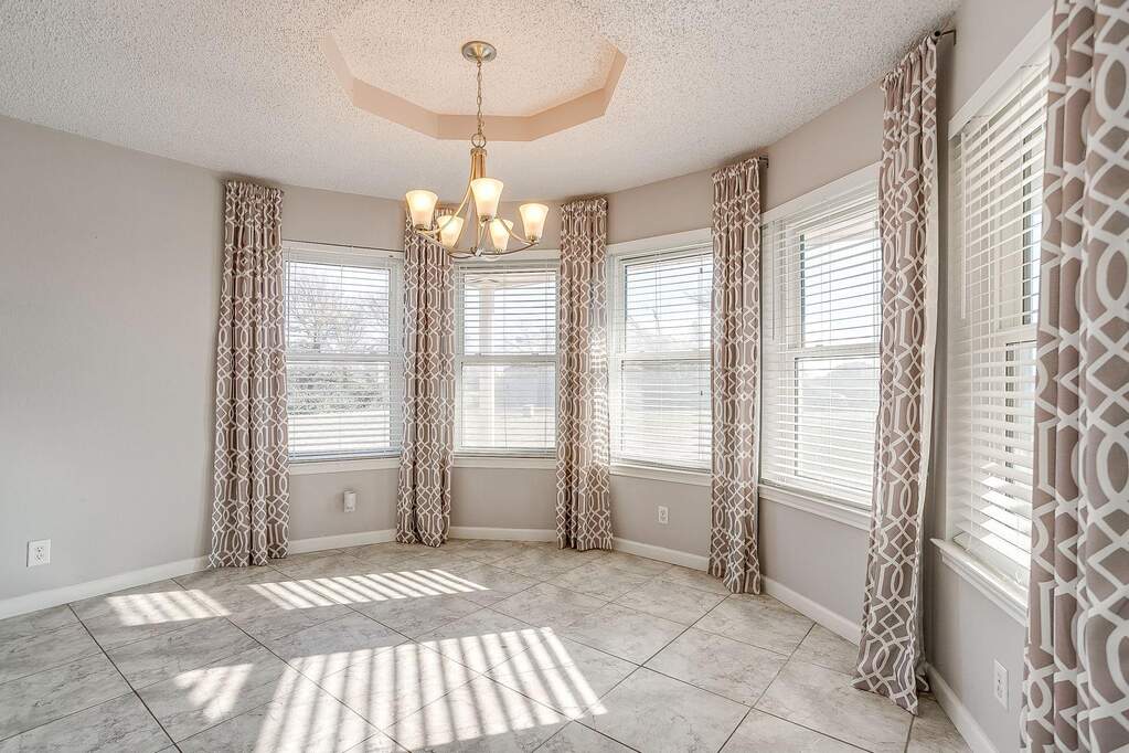 Spacious breakfast nook/dining area with bay windows.