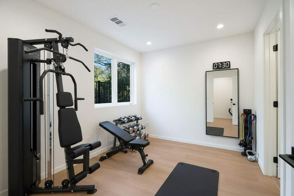 Workout area with light wood finished floors and recessed lighting