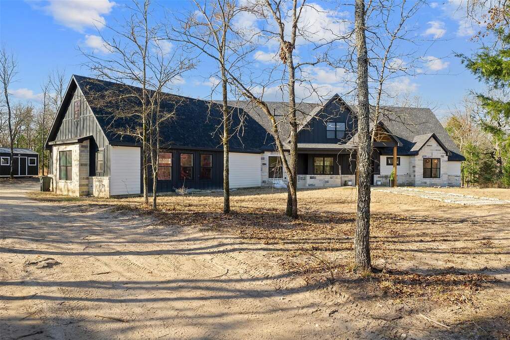View of front of house with a porch, board and batten siding, and dirt driveway