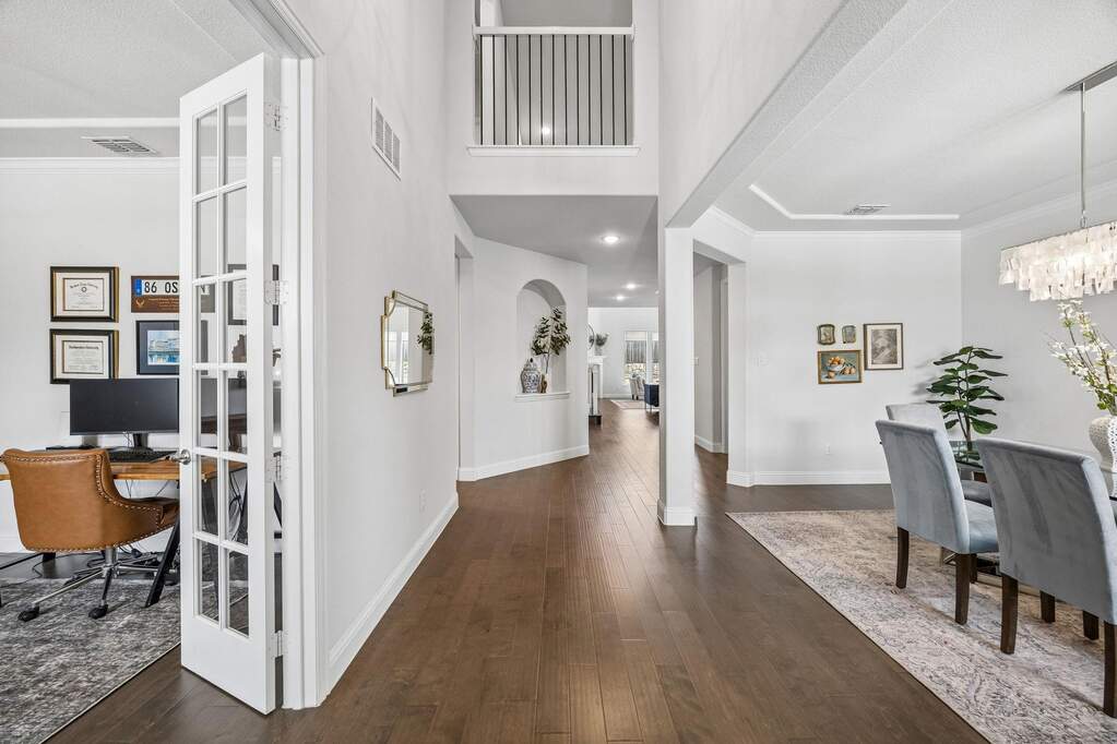 Foyer entrance featuring dark wood finished floors, hanging lights, and crown molding