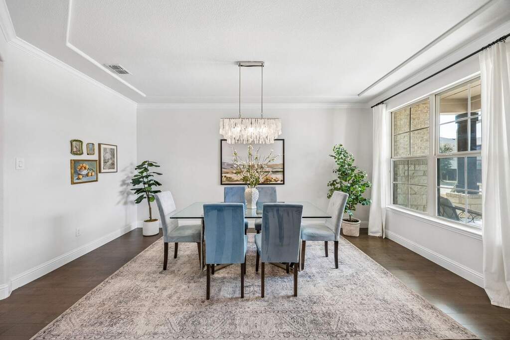 Dining space featuring dark wood finished floors, a chandelier, and ornamental molding