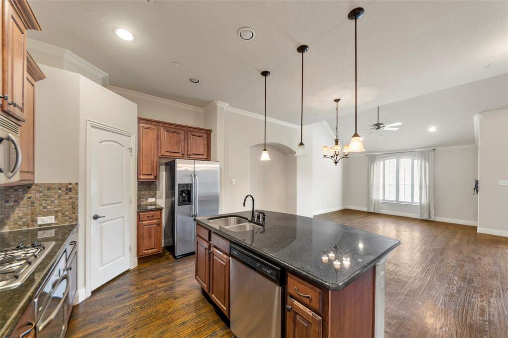 Another view of spacious kitchen with open concept dining and living space.  Kitchen island offers another dining space.  Also features SS appliances, walk in pantry and gas cook top.