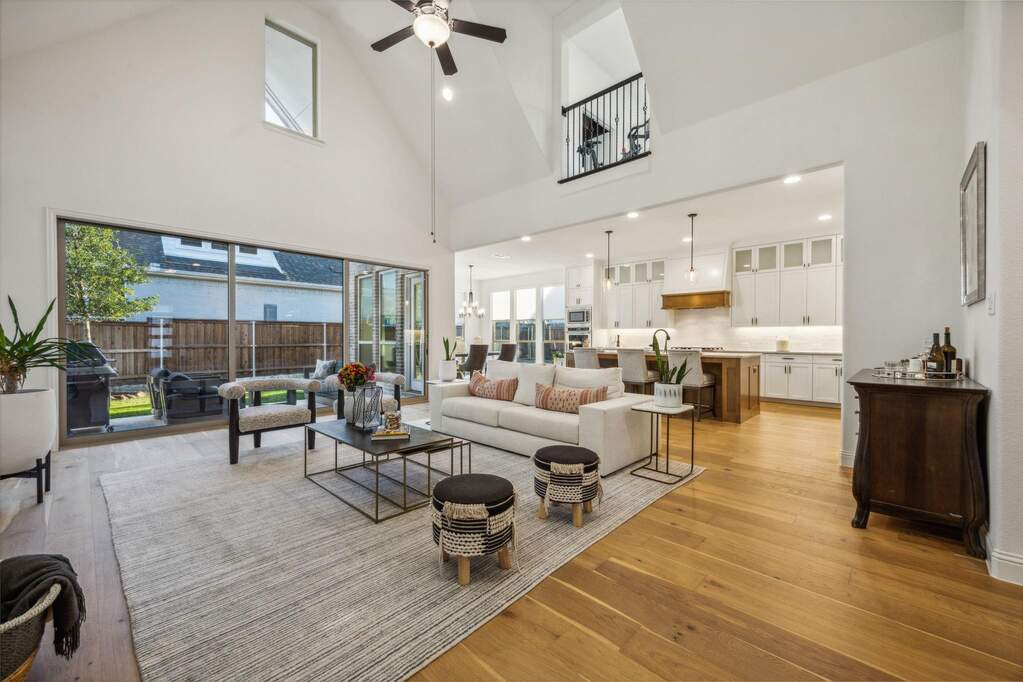 Living room featuring ceiling fan, high vaulted ceiling, and light hardwood / wood-style flooring