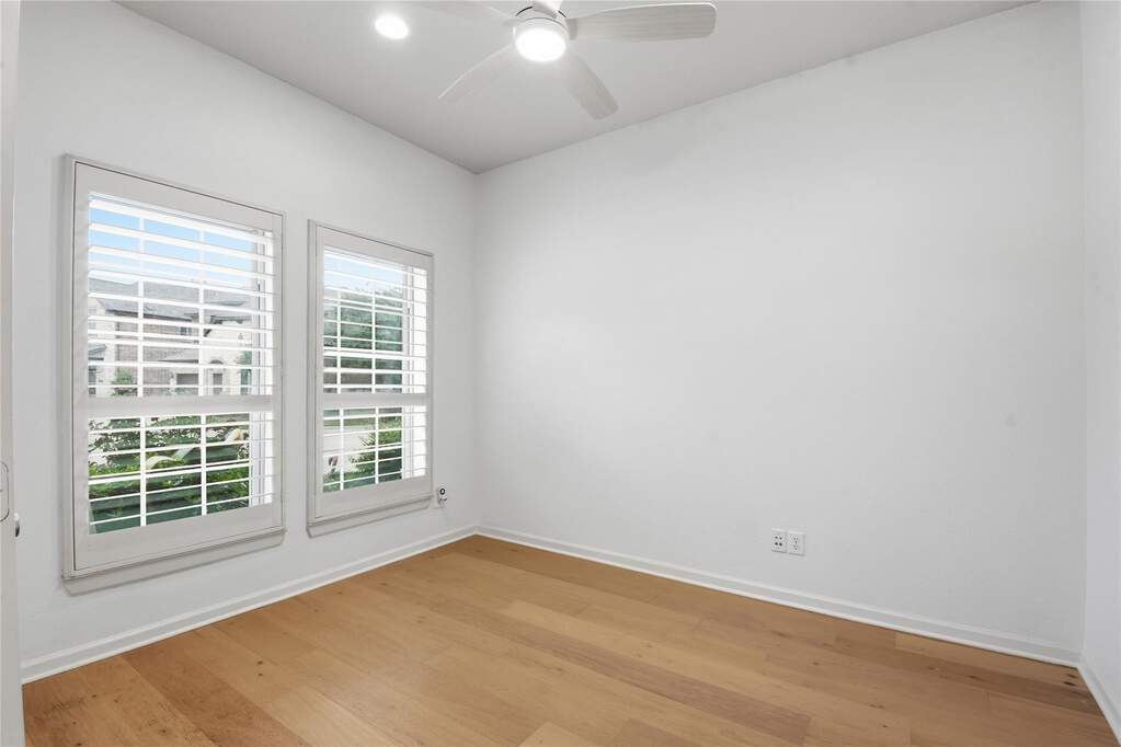 Office with French doors with white plantation shutters, natural wood-finish flooring, recessed lighting, and a ceiling fan