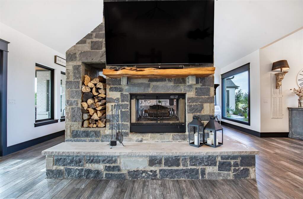 Stunning custom styled double wood burning fireplace opens to living and dining areas