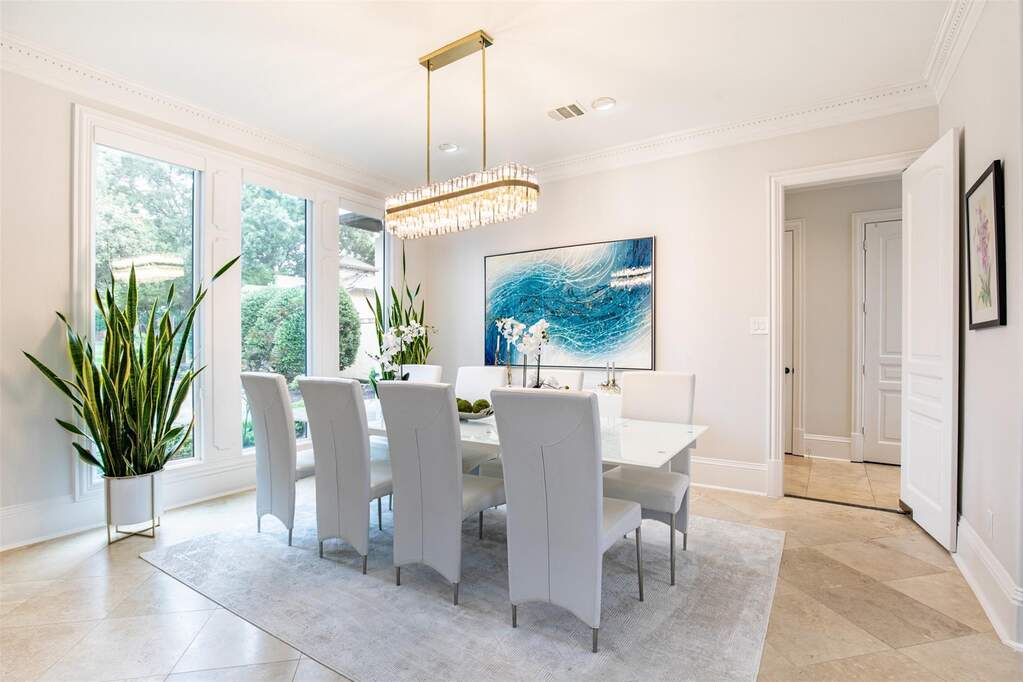 Dining area with expansive windows, decorative crown molding, and neutral wall tones