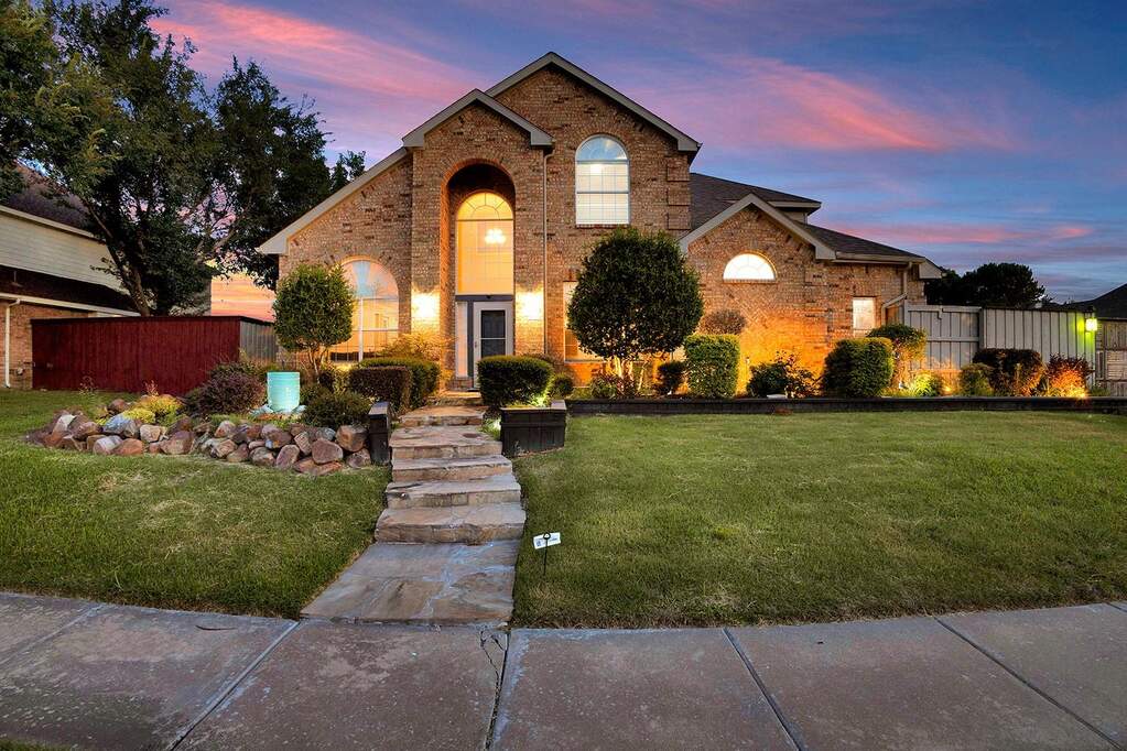 Brick exterior residence featuring an arched entry window and front door