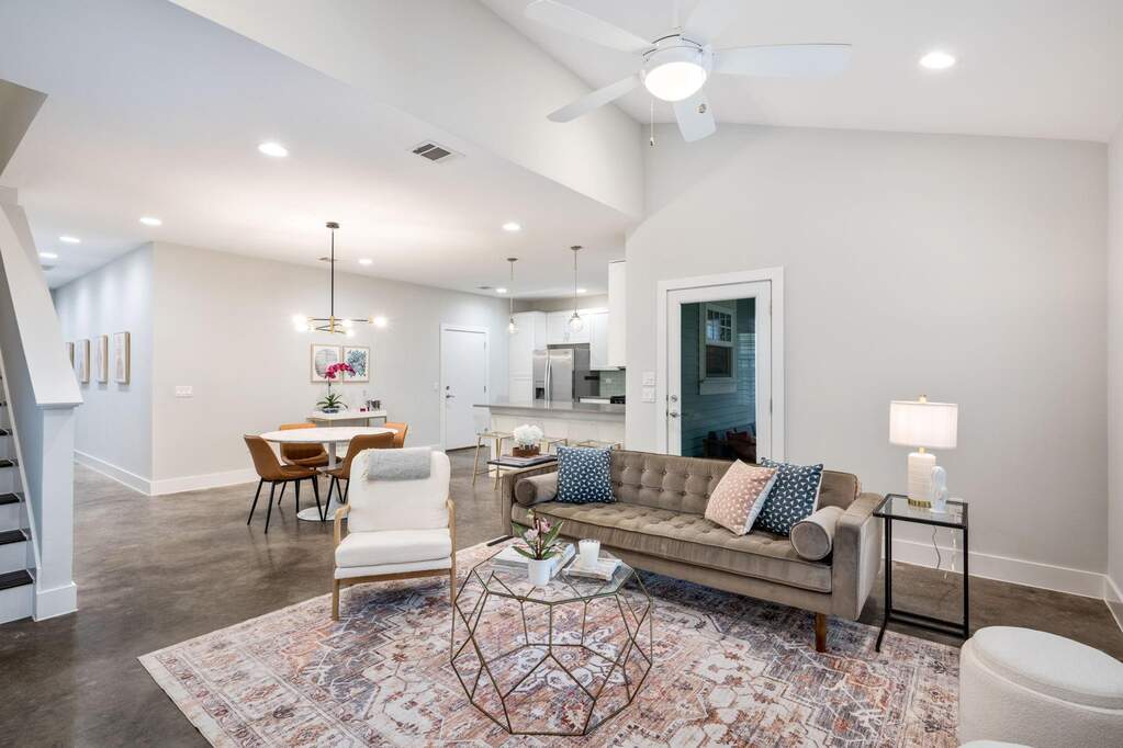 Seamless flow between the kitchen, dining, and living areas with soaring ceilings and polished concrete floors.
