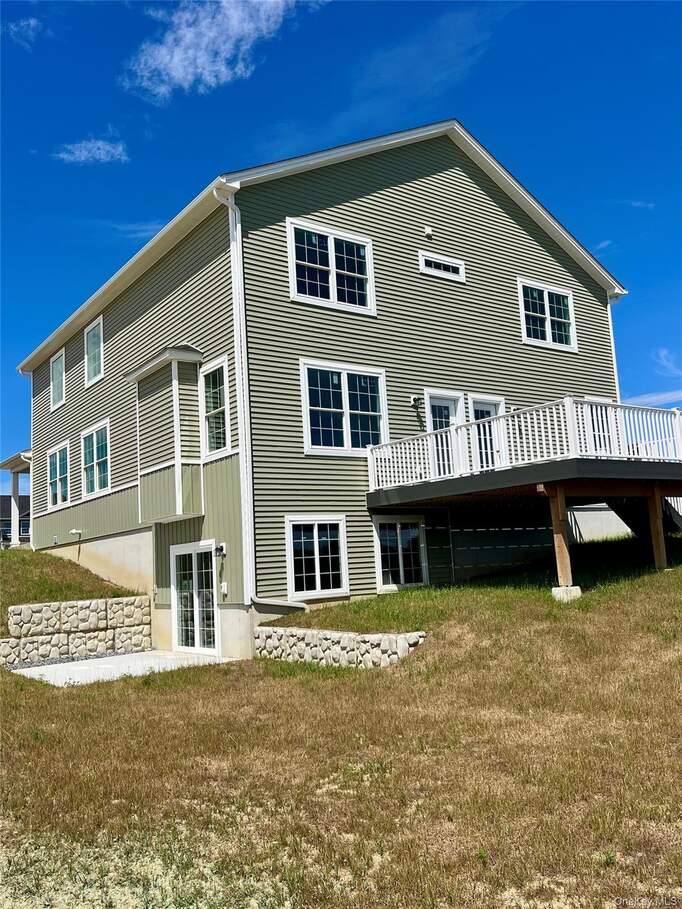 Back of house with a yard and a deck