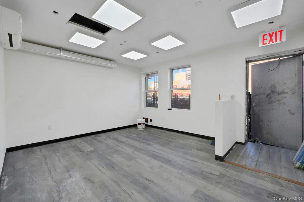 Spare room featuring light wood-style flooring and a wall mounted air conditioner