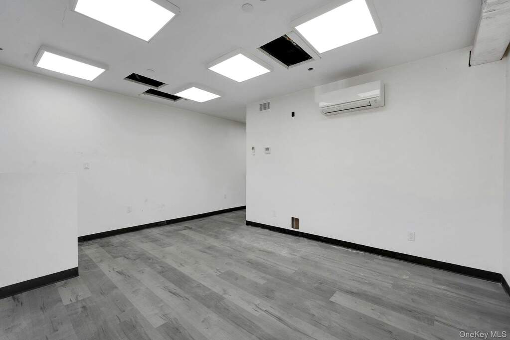 Spare room featuring light wood finished floors and a wall mounted air conditioner