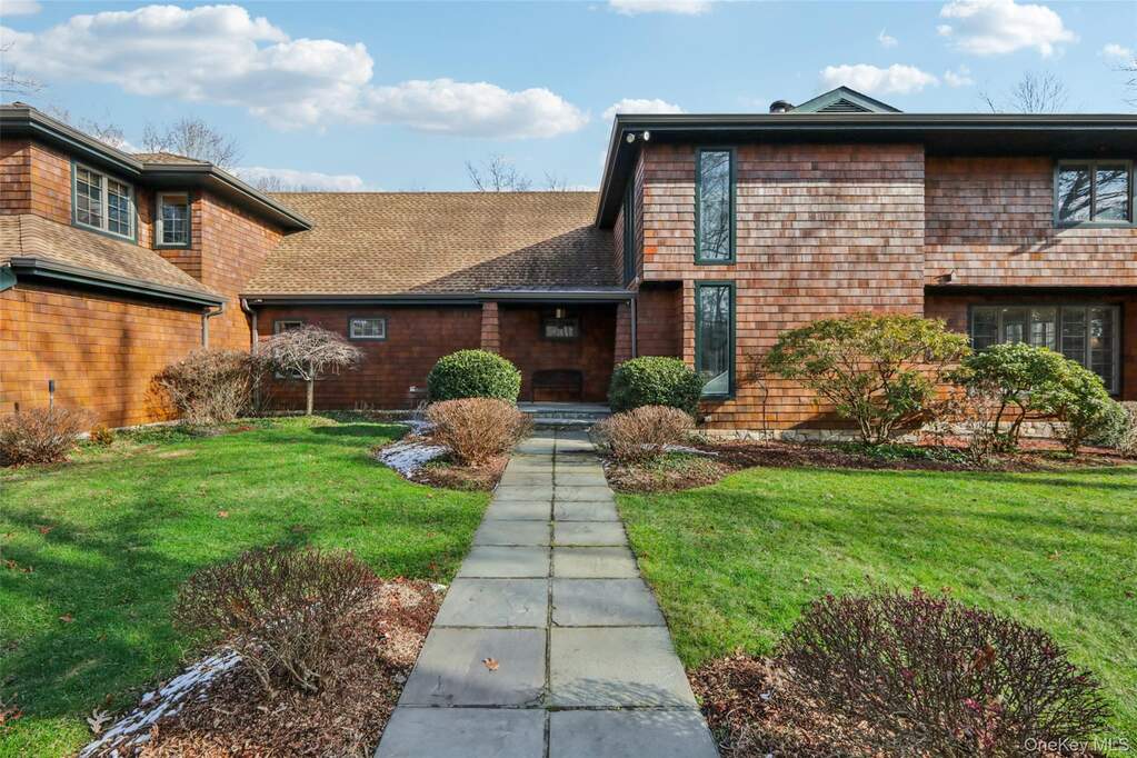View of front of house featuring a front yard and a shingled roof