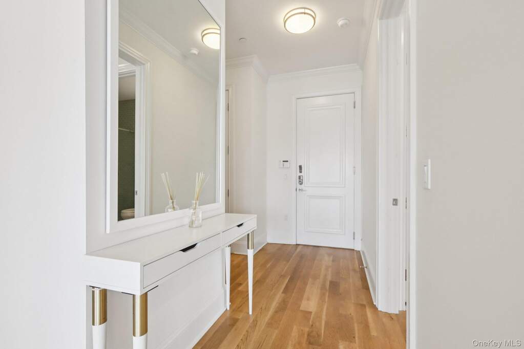 Hallway featuring crown molding and light wood finished floors