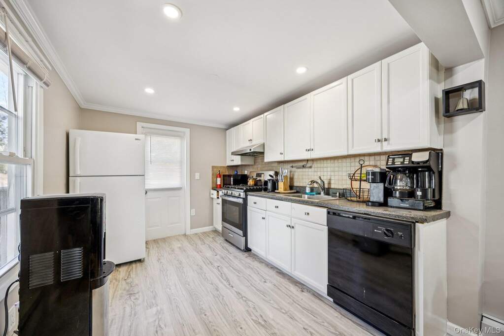 Kitchen with brand new flooring and door leading out to the backyard & deck