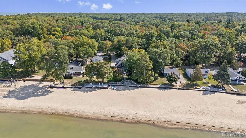 Drone / aerial view of a heavily wooded area and a nearby body of water