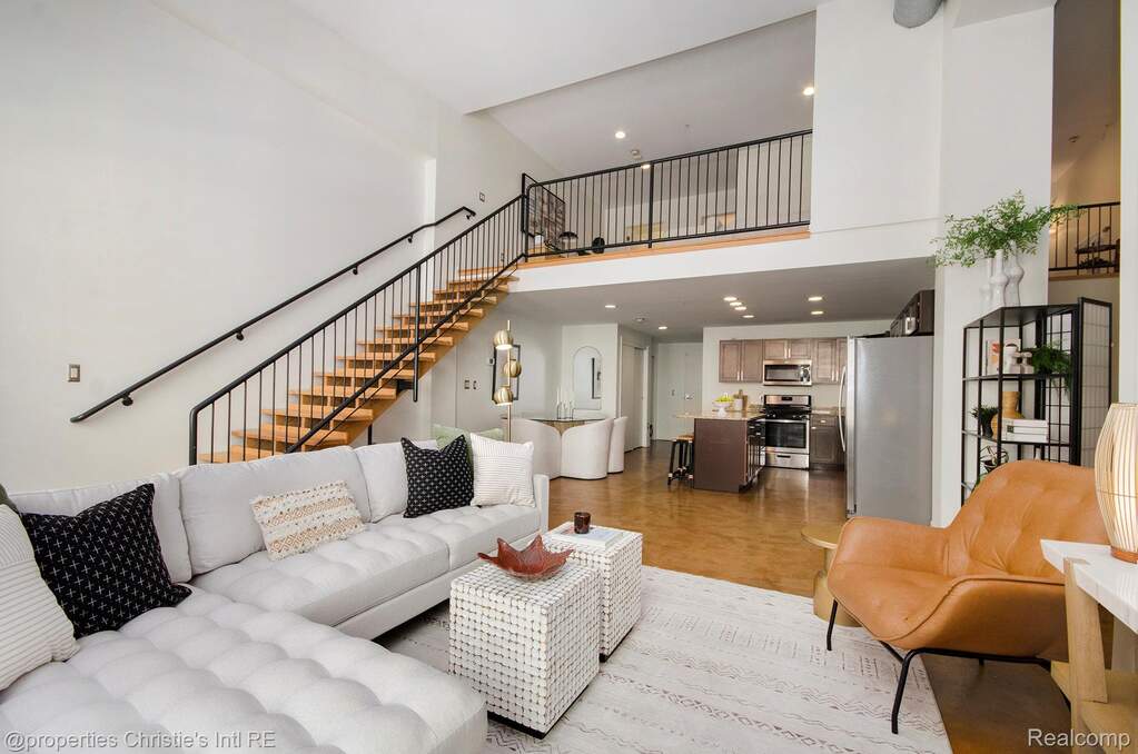 Living area featuring a high ceiling, stairway, and recessed lighting