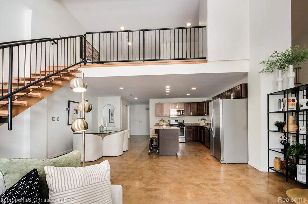 Living room with recessed lighting, a high ceiling, and stairway