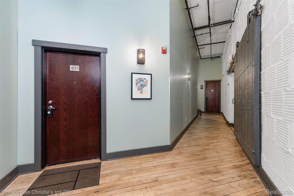 Hall with light wood-style floors and a high ceiling