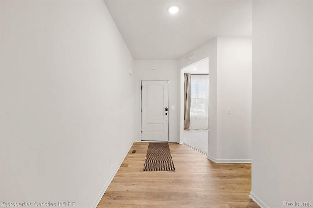 Hall with light wood-style flooring and recessed lighting