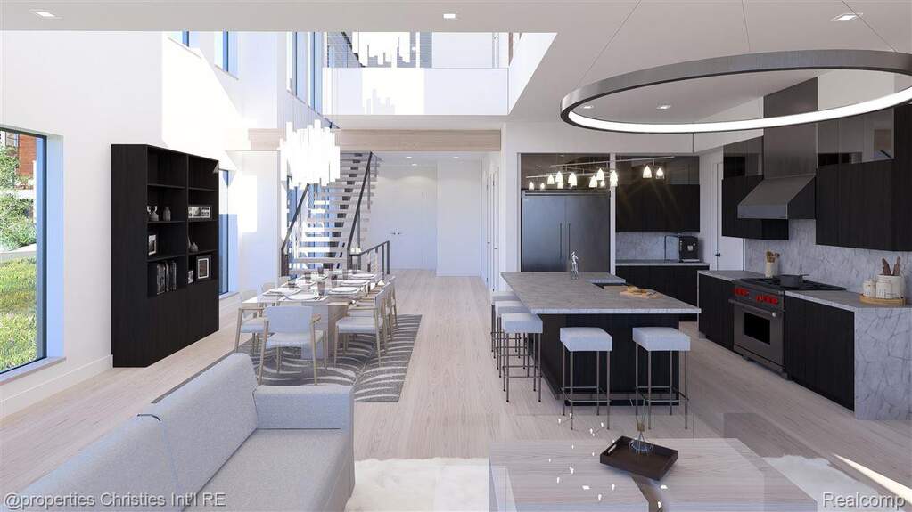 Living area featuring stairway, light wood-type flooring, recessed lighting, and a towering ceiling