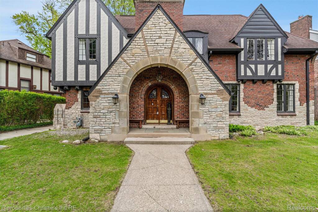 Entrance to property with stone siding and a yard