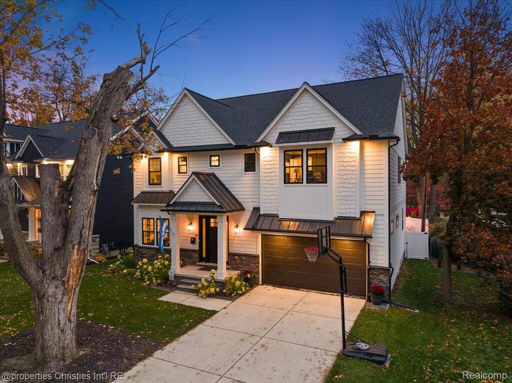 View of front of home featuring a standing seam roof, a metal roof, a front yard, driveway, and a shingled roof