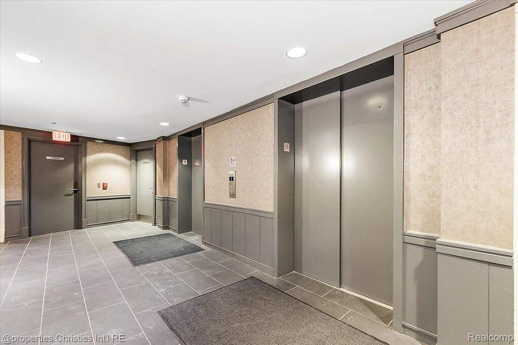 Common area with wainscoting, a decorative wall, and wallpapered walls