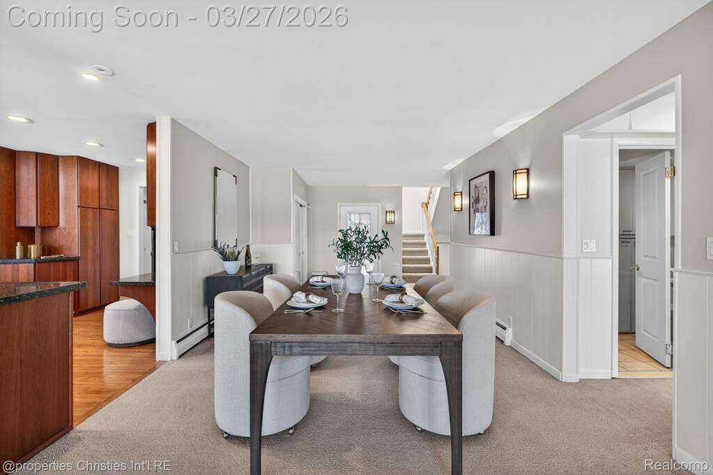 Dining room with wainscoting, baseboard heating, and light colored carpet