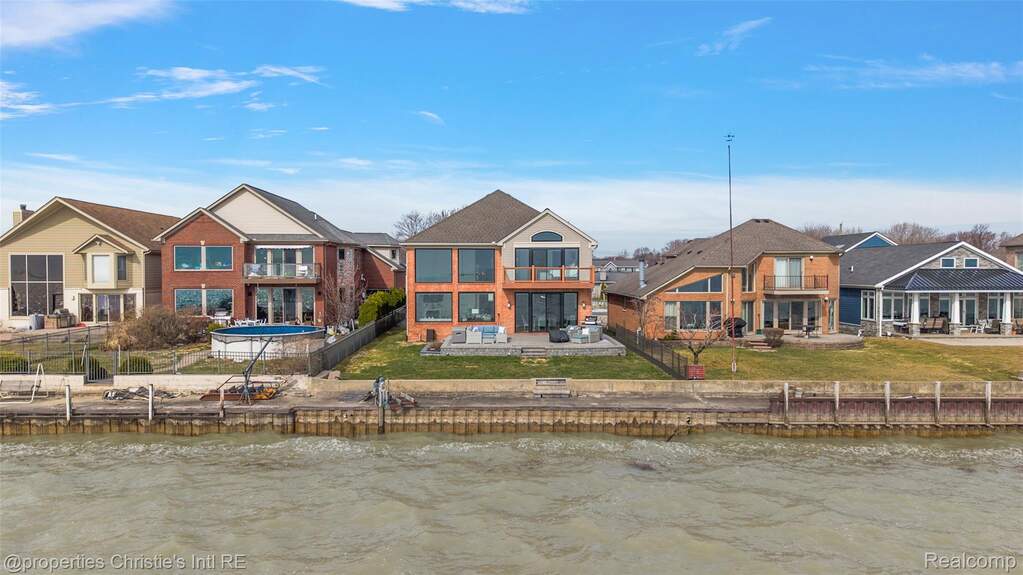 Back of property featuring a water view and a residential view