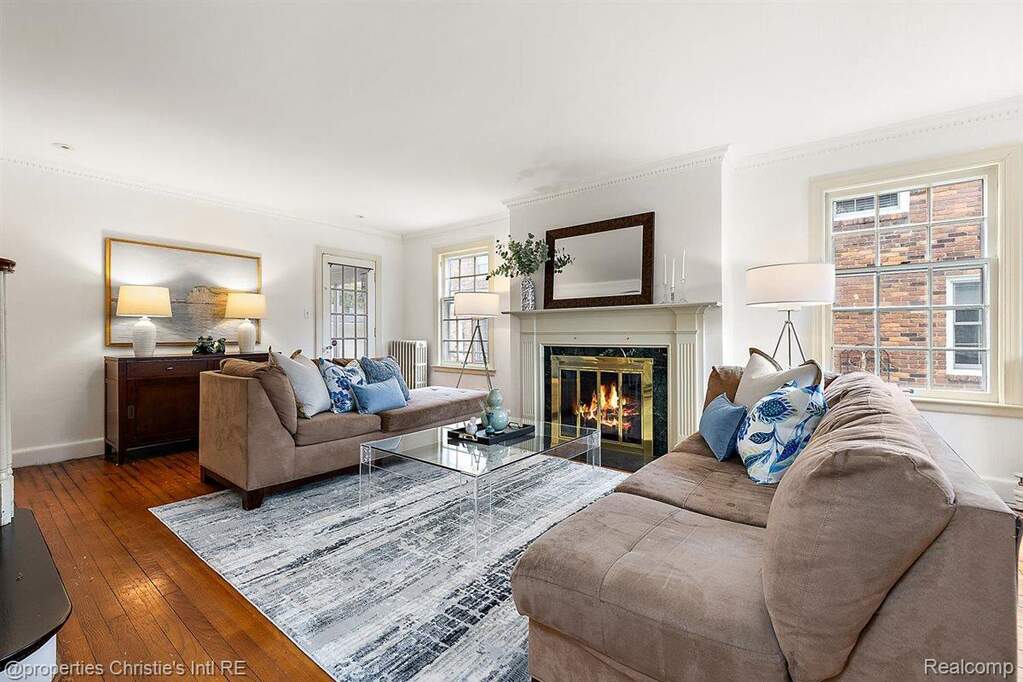 Living room with wood-type flooring, a fireplace, and crown molding