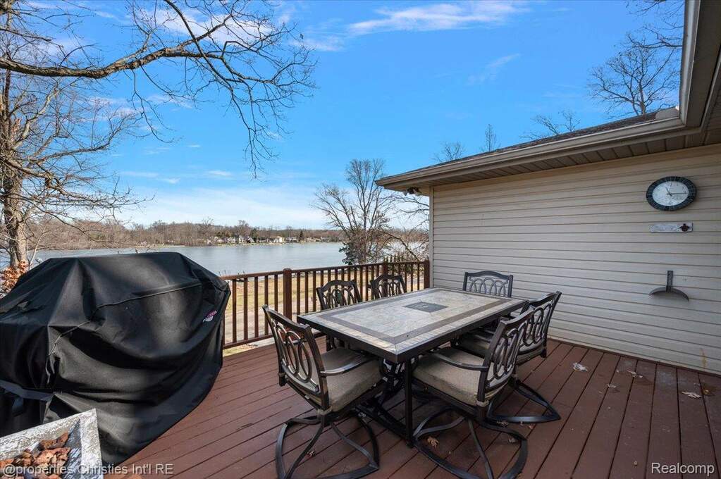 Deck featuring a grill, outdoor dining space, and a water view