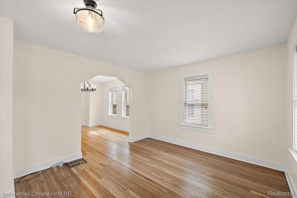 Empty room featuring light wood-style flooring and arched walkways