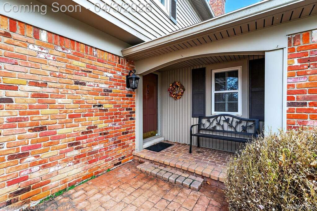 Doorway to property with brick siding and covered porch