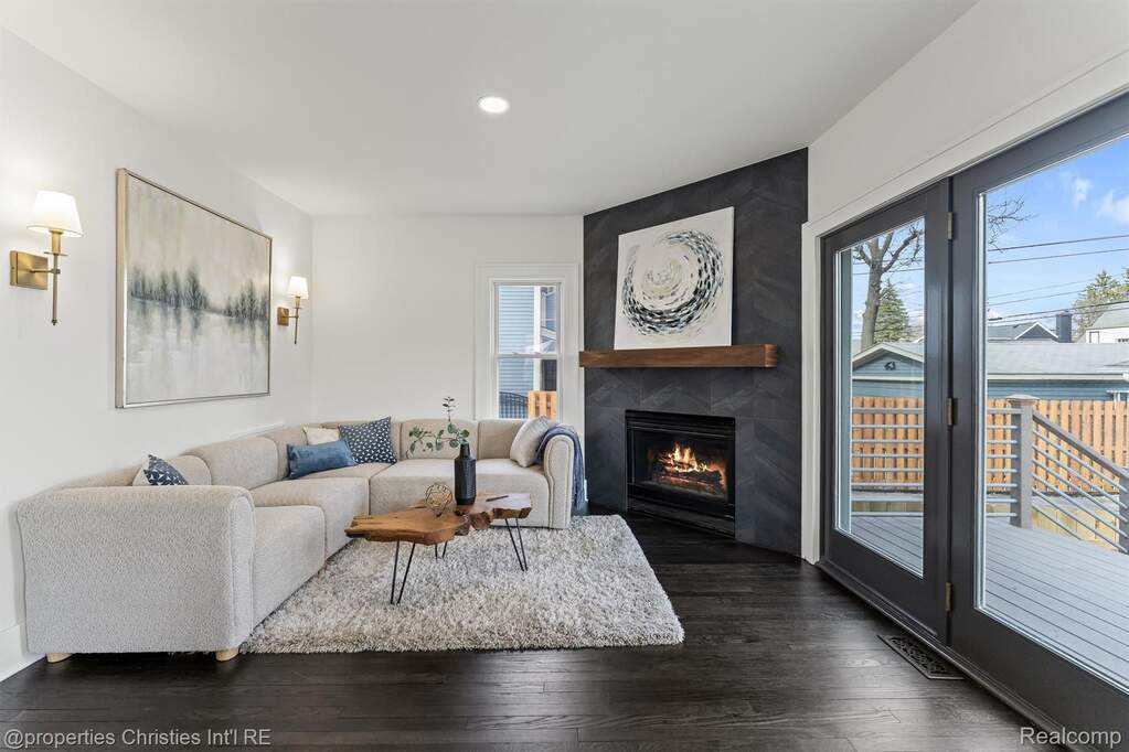 Living room featuring dark wood-type flooring, a large fireplace, and recessed lighting