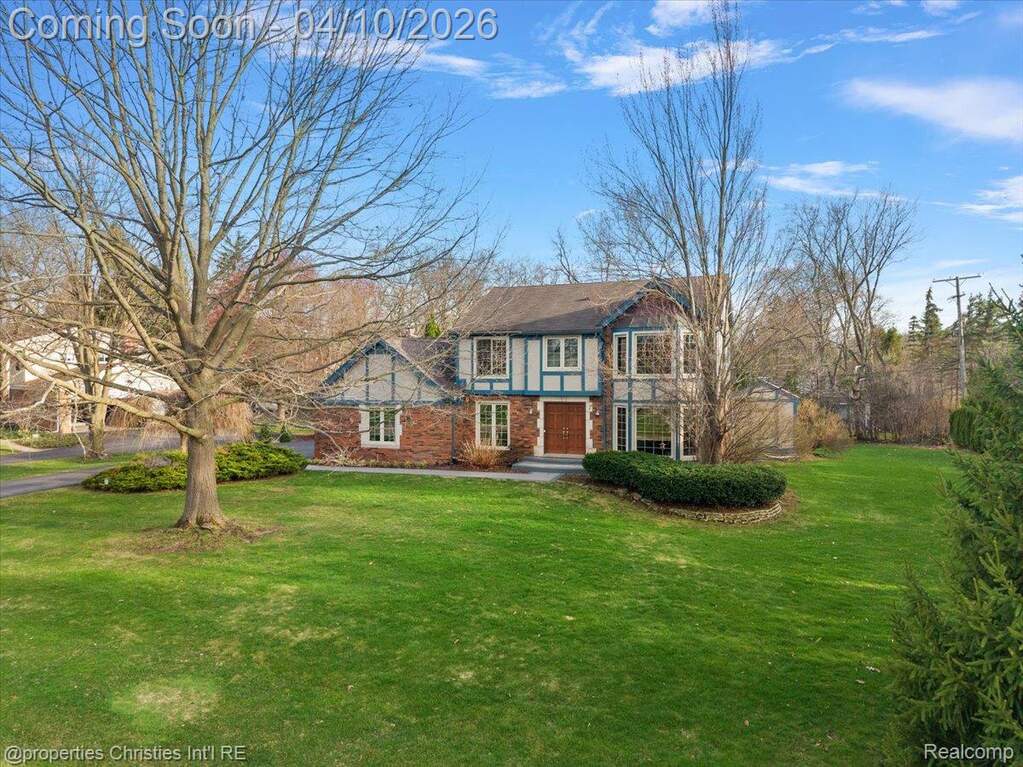 Tudor-style house with a front lawn and brick siding