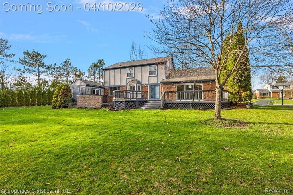 Back of property with a lawn and a deck