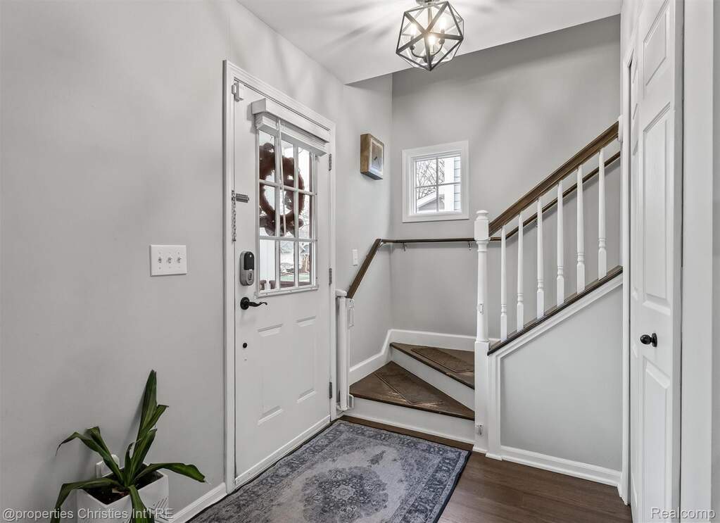 Entrance foyer featuring stairs and dark wood-style floors