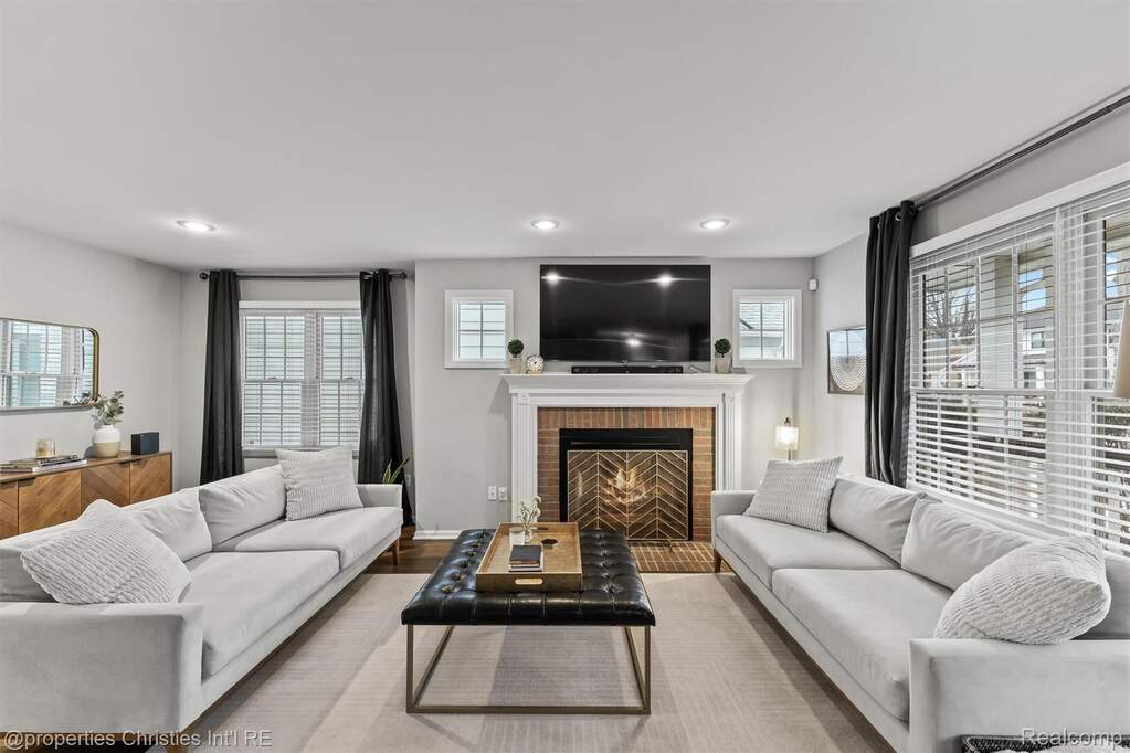 Living room featuring healthy amount of natural light, wood finished floors, a brick fireplace, and recessed lighting