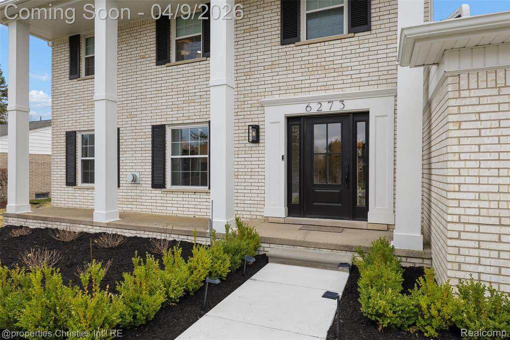 Property entrance with brick siding and covered porch