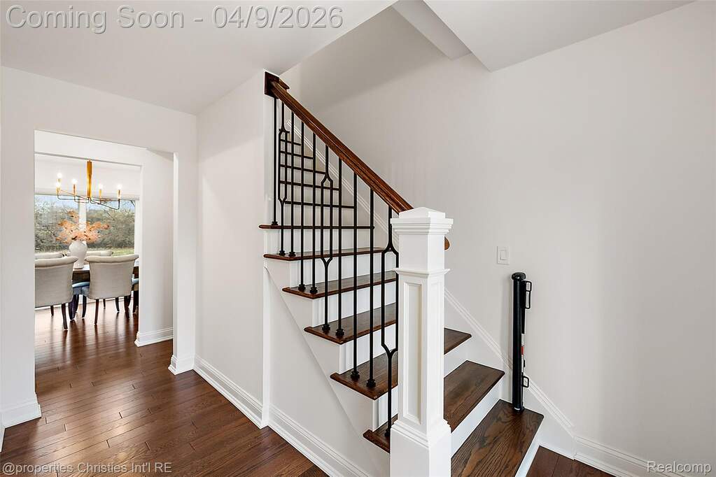 Stairs featuring wood-type flooring and a chandelier