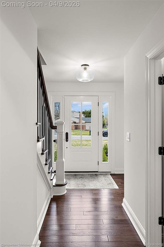 Foyer featuring stairs and dark wood-style floors