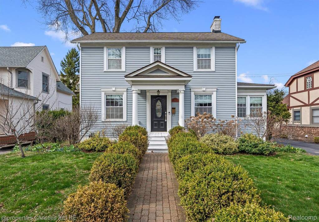Colonial house with a front lawn and a chimney