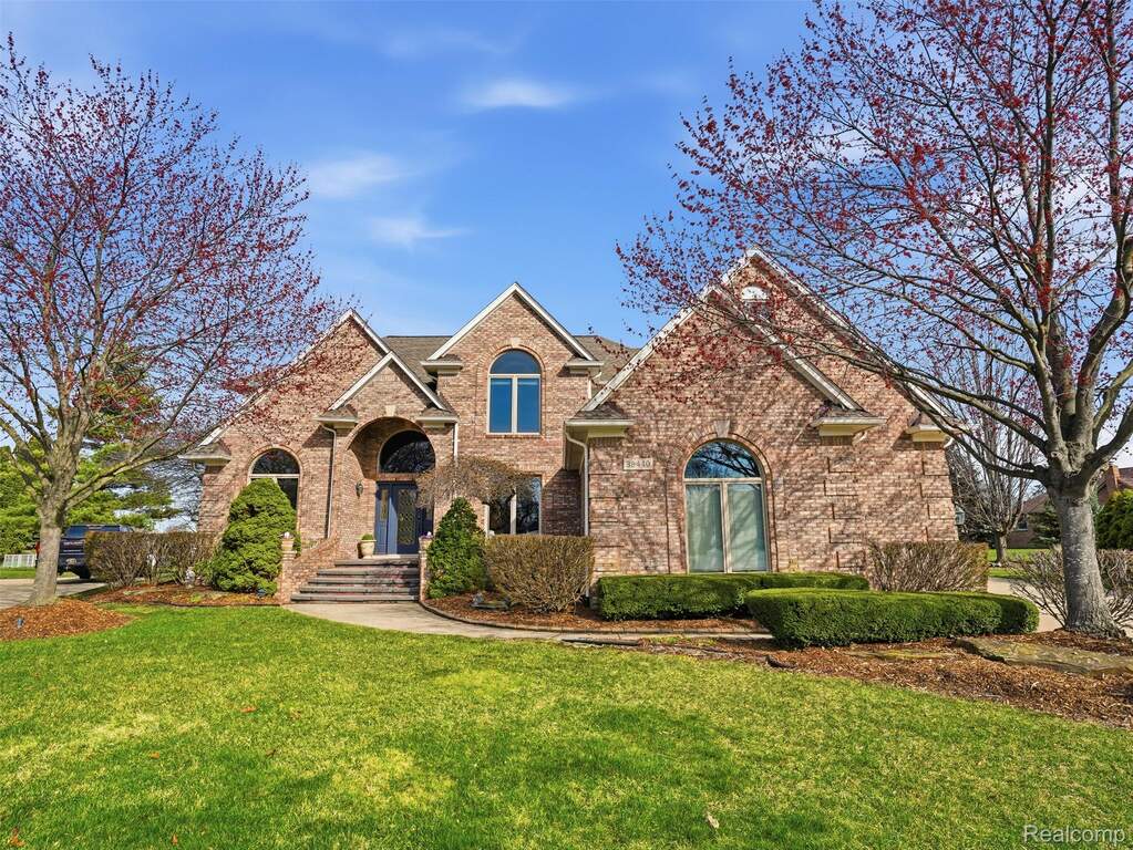 Traditional-style house with a front lawn and brick siding