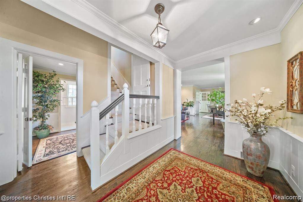 Foyer featuring dark wood finished floors, healthy amount of natural light, wainscoting, crown molding, and recessed lighting